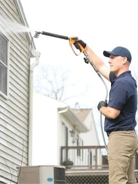 Technician providing professional house siding pressure washing in West Chester, OH